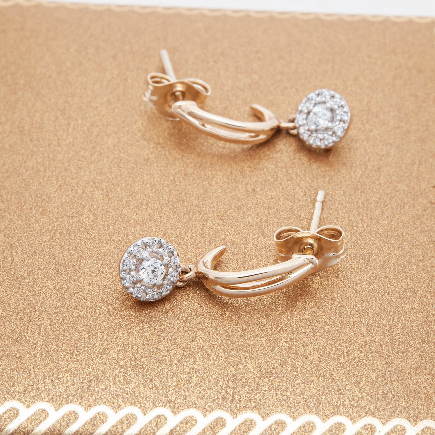 Elan Diamond Round Dangle Earrings Placed on Golden Background